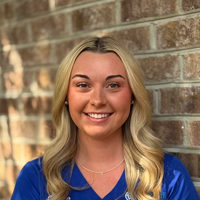Orthodontic Assistant Cassie Harris Smiling In Front Of Brick Wall