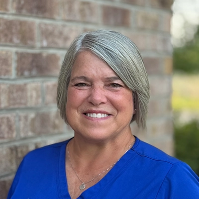 Treatment Coordinator Lisa Hales Smiling In Front Of Brick Wall