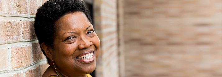 Smiling Woman Leaning Against Wall